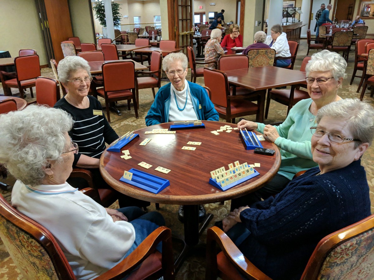 A group of seniors enjoying a table game together in a community setting.