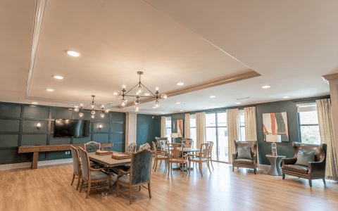 A spacious, modern dining room with elegant chandeliers and comfortable seating.