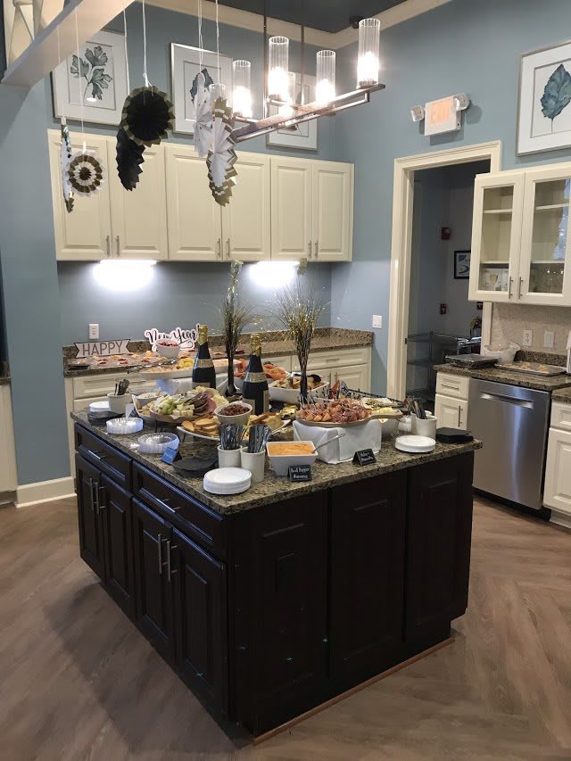 A kitchen featuring a central island set up with a buffet of various foods.