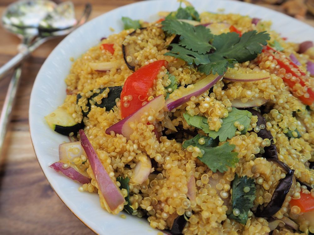 A vibrant quinoa salad with assorted vegetables and fresh herbs.