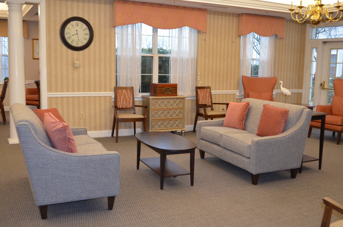 A cozy living room with sofas, armchairs, and a central coffee table.