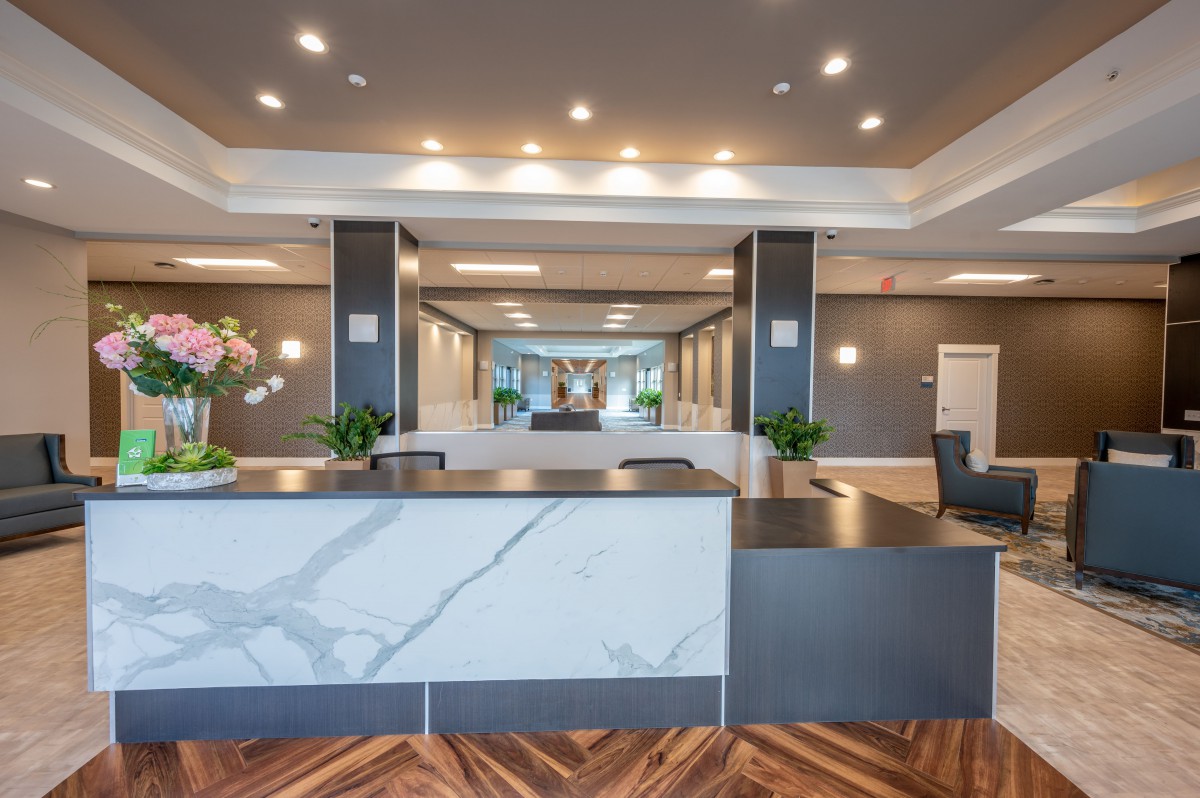 A modern hotel reception area with a sleek desk and stylish lighting.