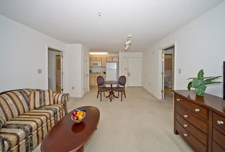 A cozy apartment living room with a dining area and kitchen in view.