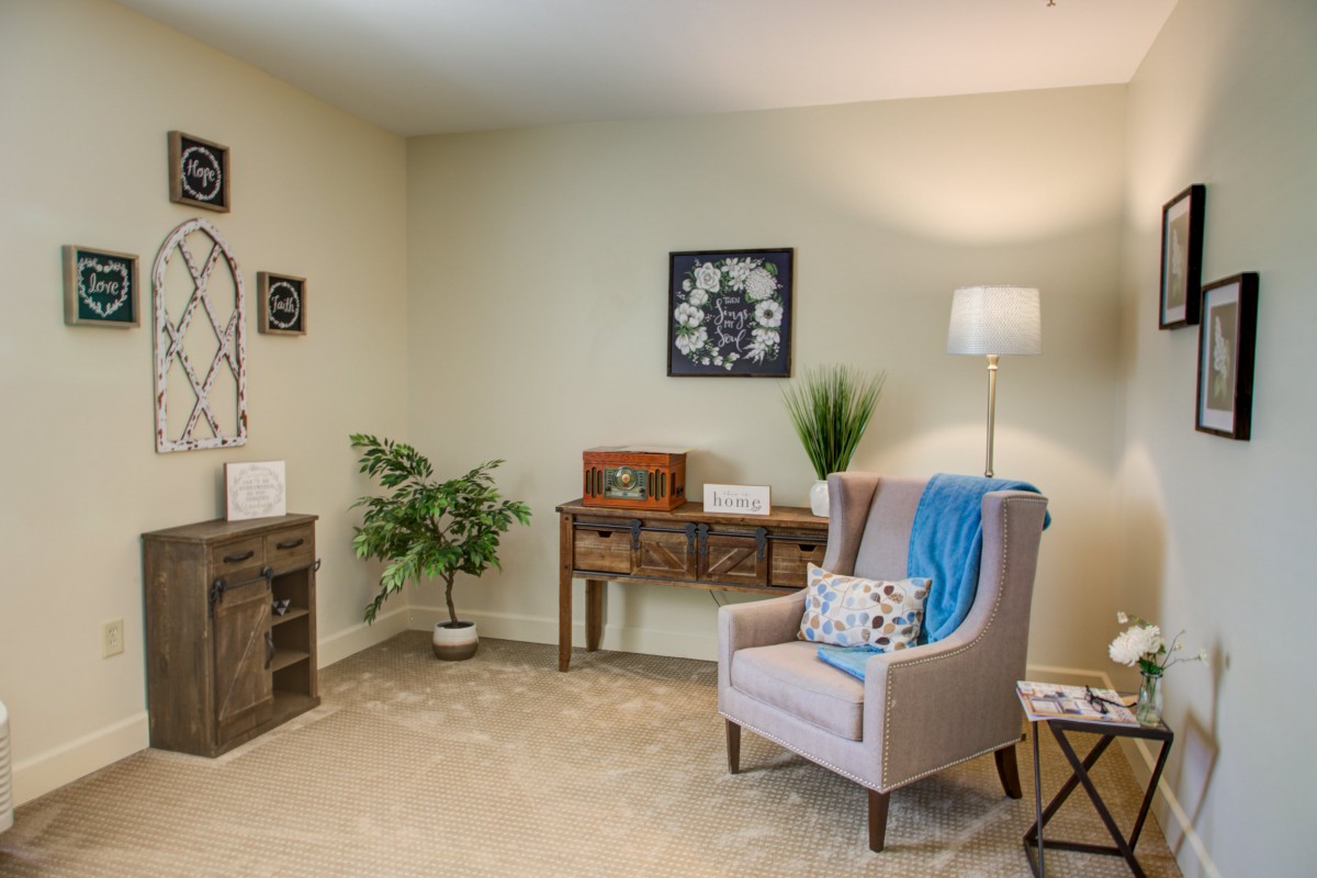 A cozy living room with an armchair, floor lamp, and decorative elements.