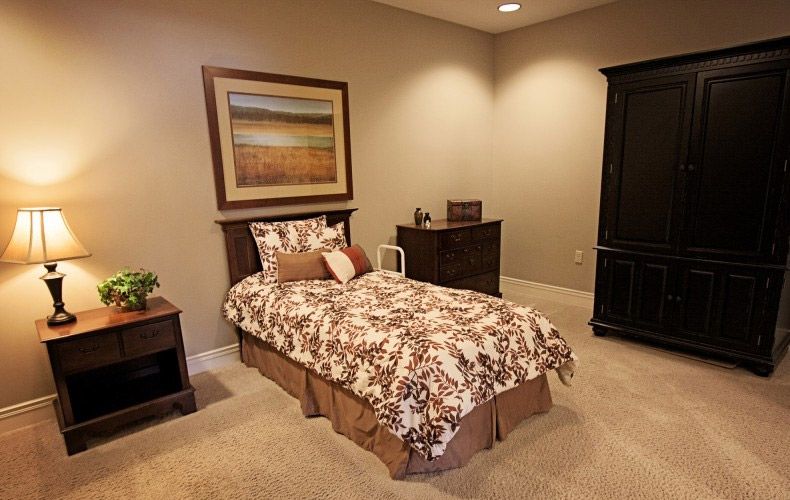 A cozy bedroom with a single bed, nightstand, and decorative painting on the wall.