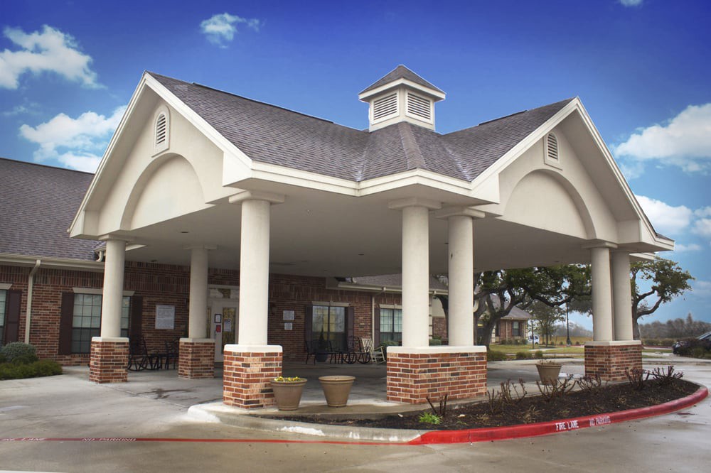 A building entrance featuring large columns and a covered walkway.