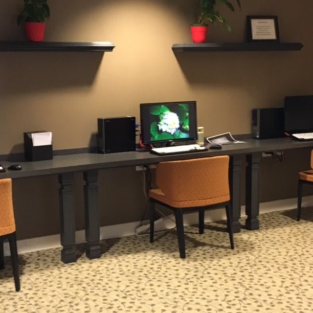 A modern workspace featuring computers and comfortable seating.