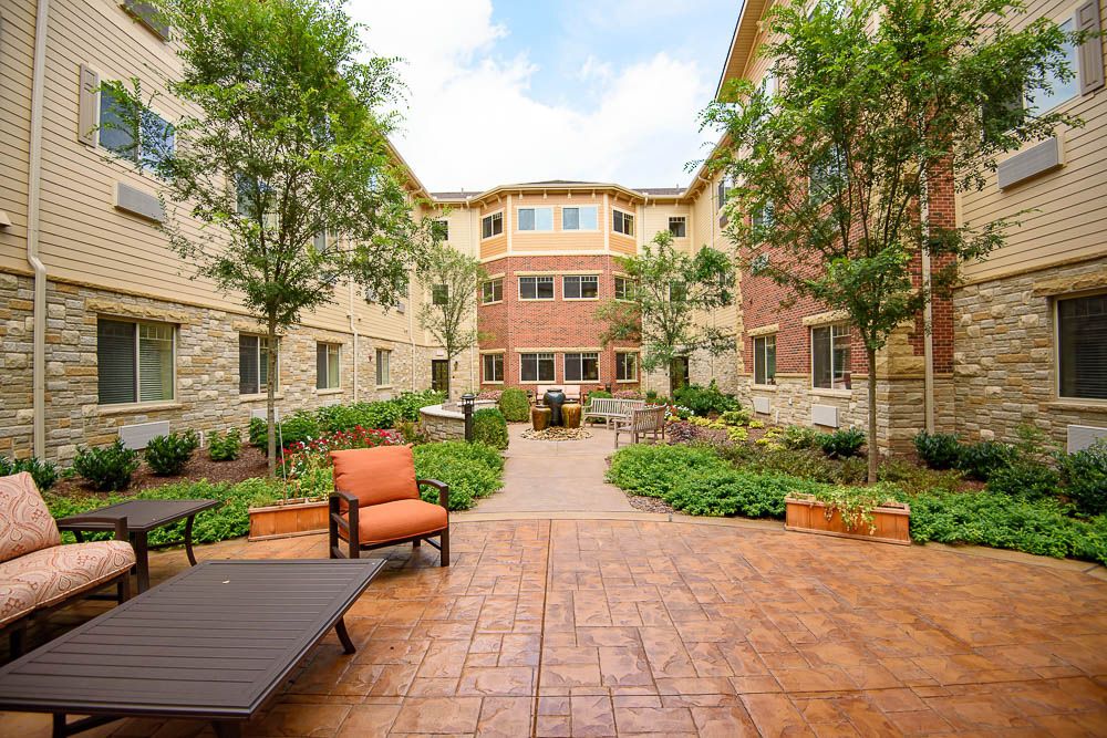 A beautifully landscaped apartment courtyard with seating areas and greenery.
