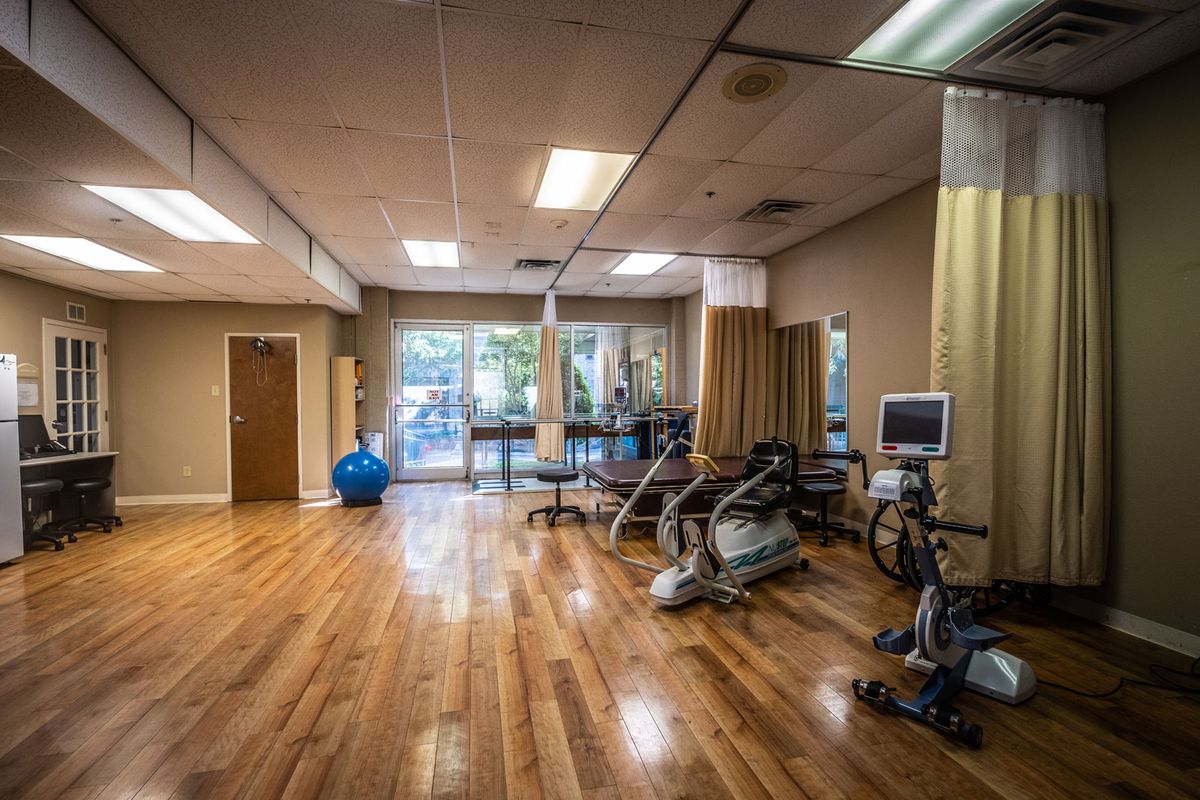 A well-equipped physical therapy room with exercise machines and a spacious layout.