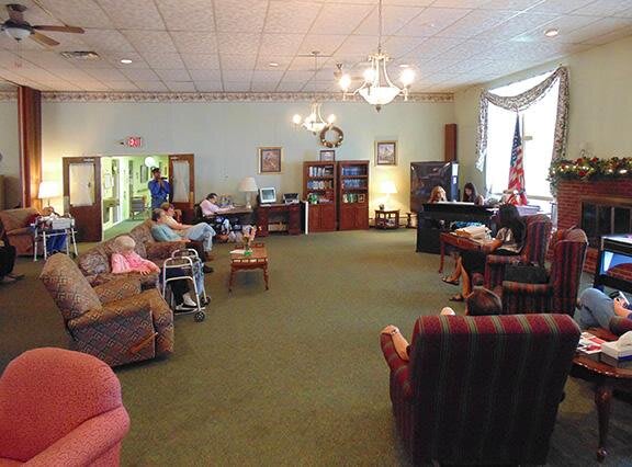 A cozy lounge area in a nursing home with seniors relaxing and socializing.
