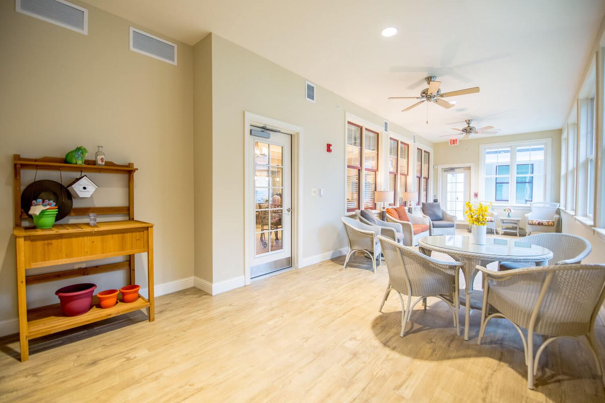A bright and spacious dining area with ceiling fans, natural light, and a wooden floor.