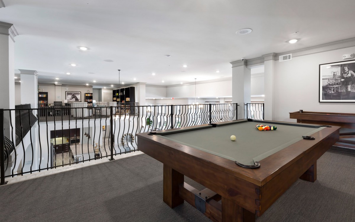 Modern game room with a pool table and stylish decor.