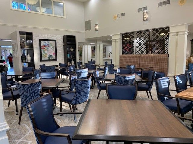 A modern, empty dining area with neatly arranged tables and chairs.