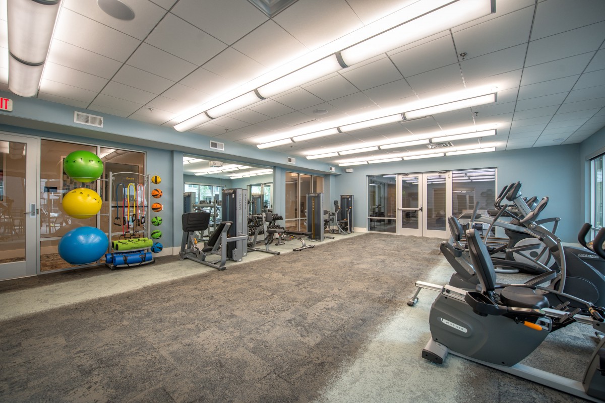 A modern gym equipped with various exercise machines and equipment.
