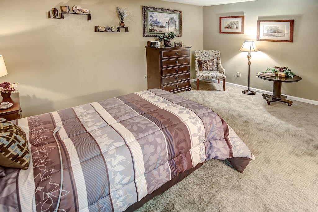 A cozy, well-decorated bedroom with a striped bedspread and elegant furnishings.