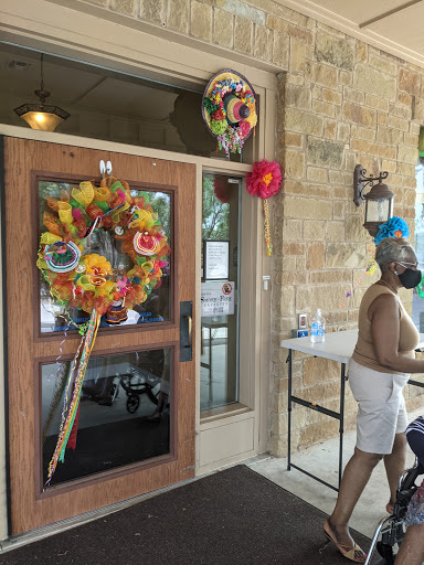 A vibrant entrance adorned with colorful floral decorations, welcoming visitors on a sunny day.