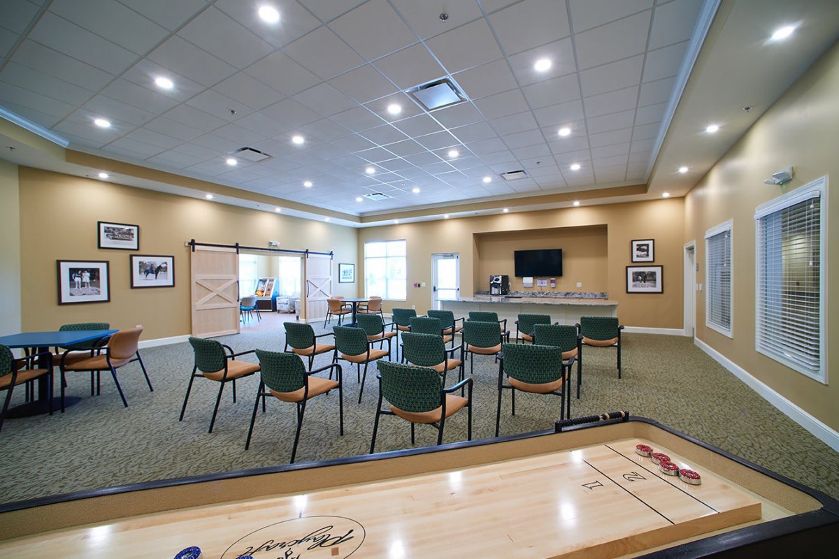 A well-equipped conference room with chairs arranged for a meeting and a screen at the front.