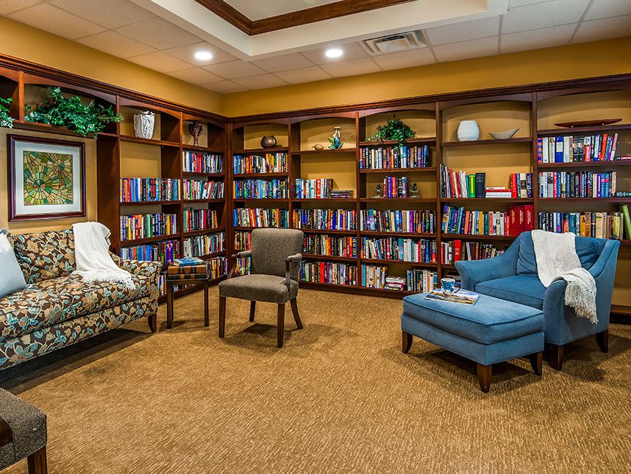 A cozy library corner with bookshelves filled with books and comfortable seating.