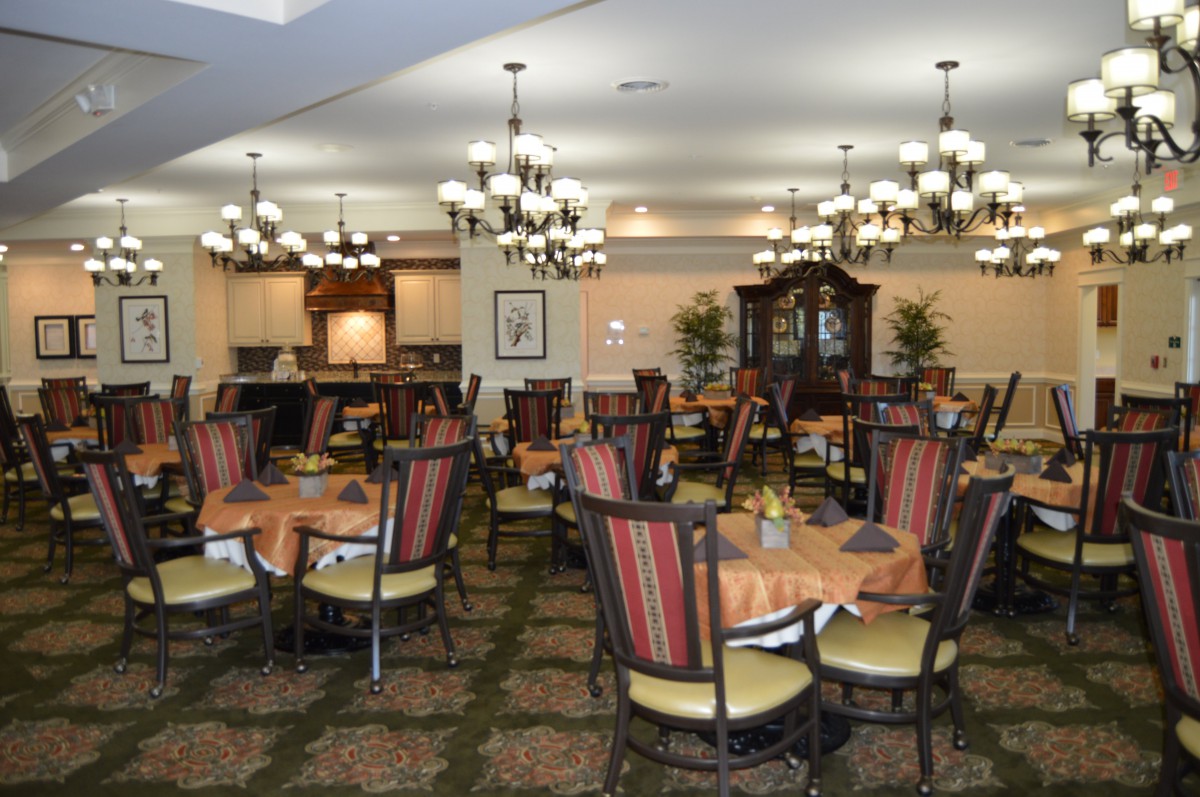 Elegant dining room with multiple tables and chandeliers.