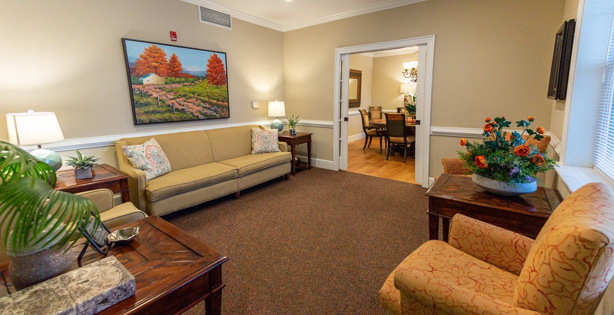 A cozy living room with comfortable seating and vibrant artwork on the wall.