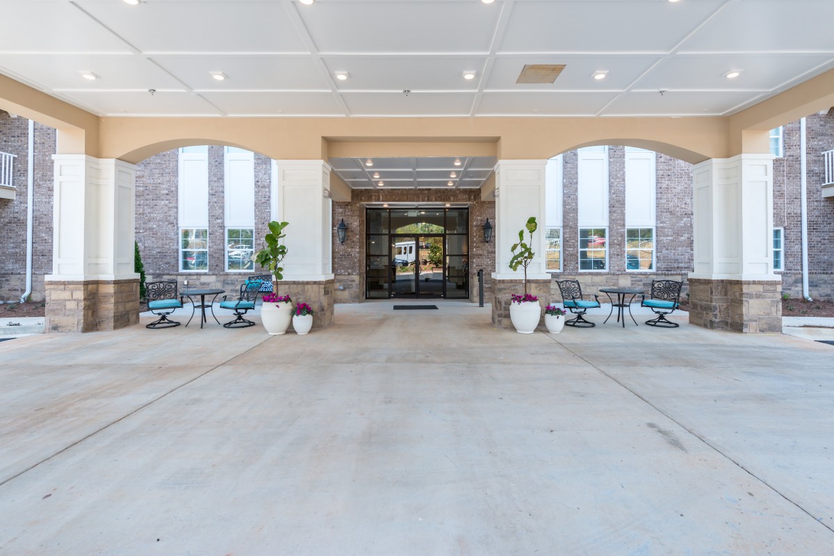 Entrance area of a building with outdoor seating and potted plants.