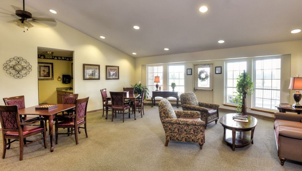 A cozy living room with multiple seating arrangements and large windows.