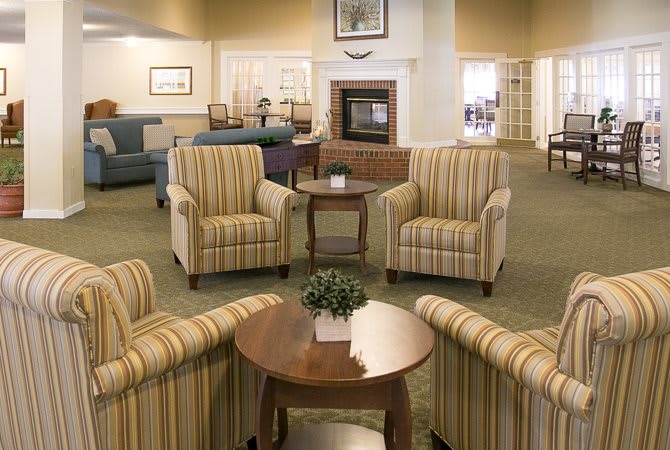 A cozy living room with striped armchairs and a sofa arranged around a coffee table.