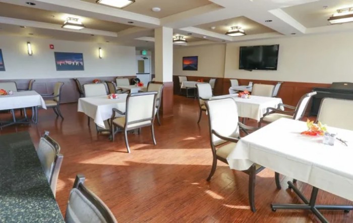 A spacious and clean dining room with neatly arranged tables and chairs.