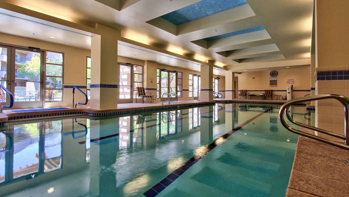 A serene indoor swimming pool with ample natural light filtering through large windows.