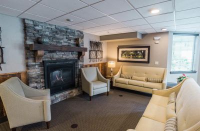 A cozy living room with a stone fireplace, comfortable seating, and modern decor.