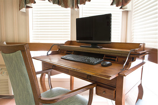 A wooden desk equipped with a computer and keyboard, creating a cozy workspace.