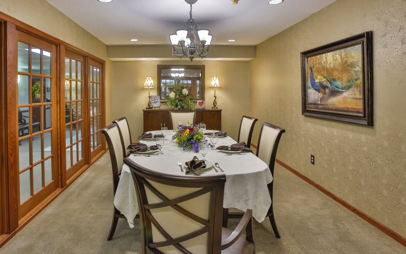 Elegantly set dining room with a central table and chandelier.
