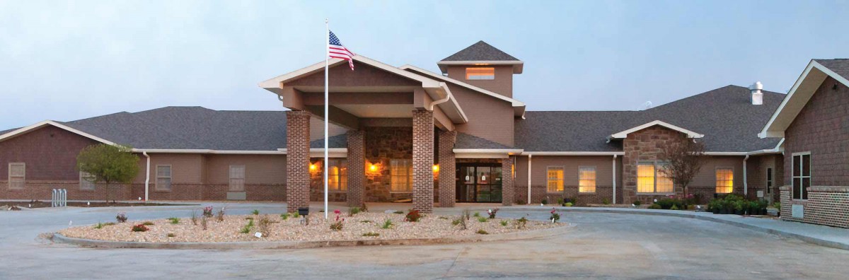 A cozy hotel entrance with brick pillars and an American flag.