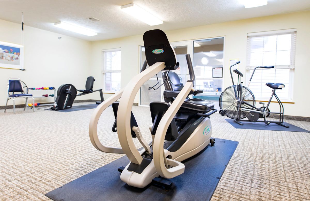 A well-equipped gym featuring various cardio machines and exercise equipment.