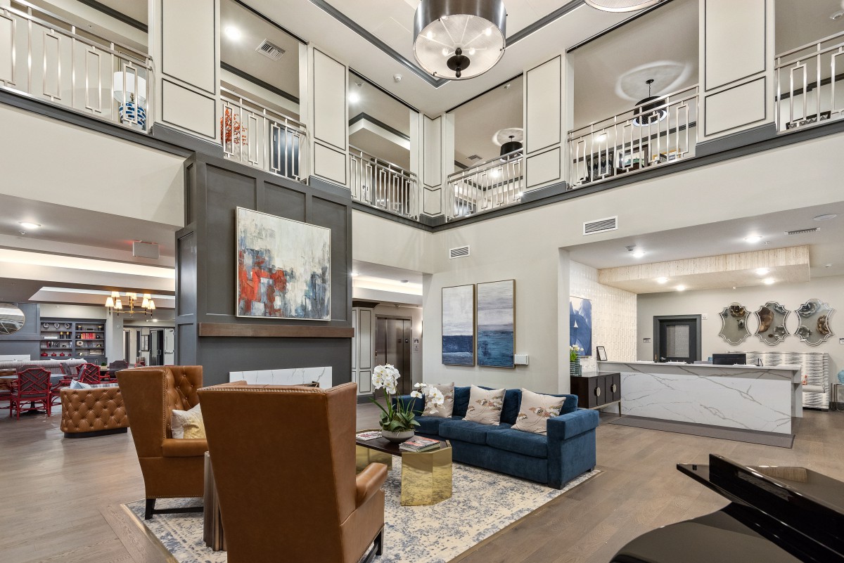 A spacious and elegantly designed living room with modern furniture and artwork.