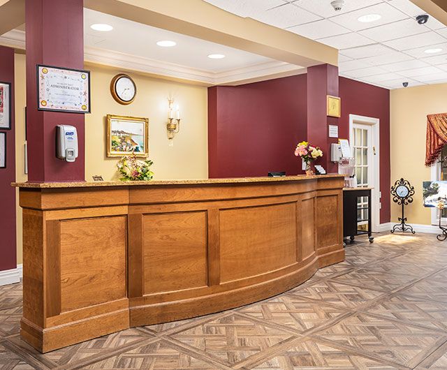 A welcoming hotel reception area with a wooden counter and warm lighting.