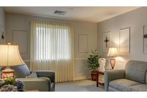 A cozy living room with a sofa, lamp, and curtains.