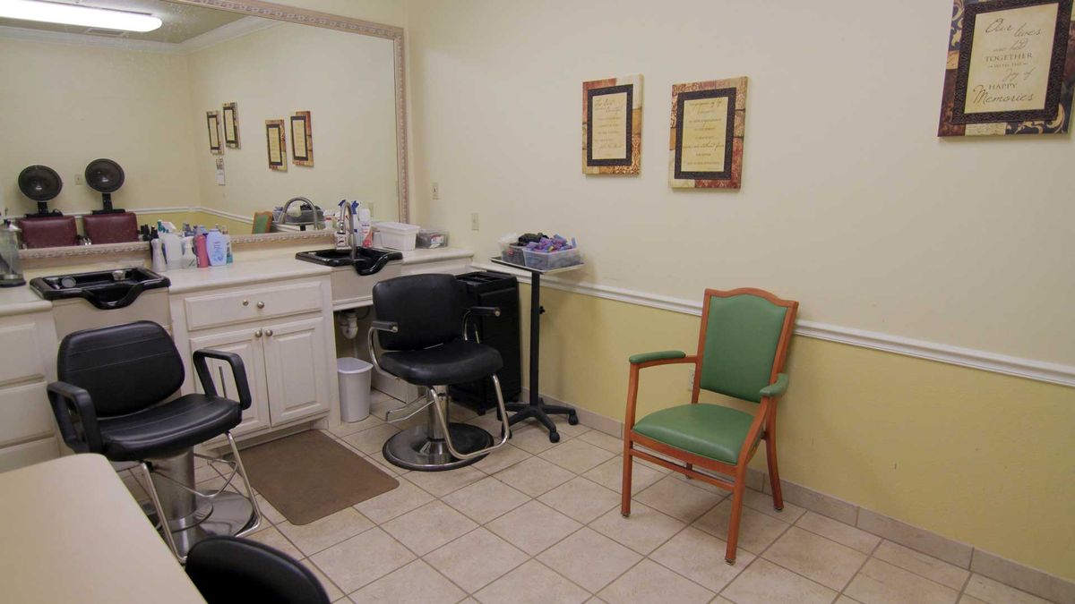 A small salon interior with a barber chair and waiting area.