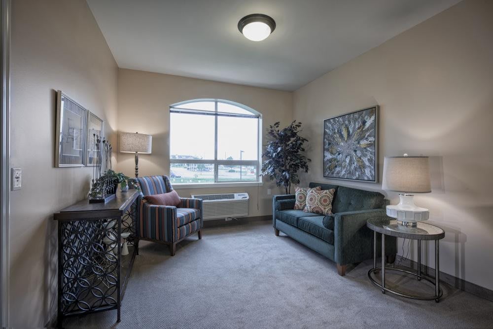 A cozy living room with a sofa, armchair, and decorative elements creating a warm atmosphere.
