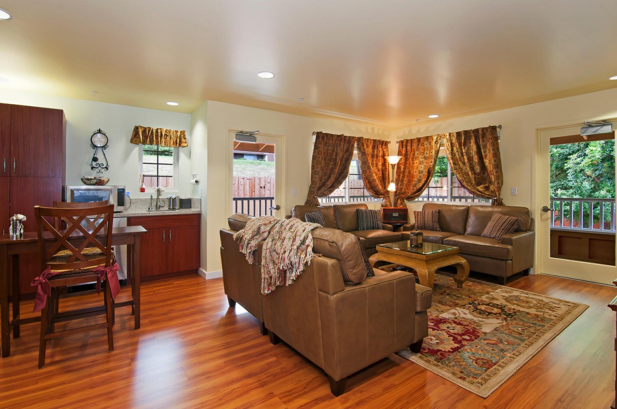 A cozy living room with sofas, a coffee table, and decorative curtains.