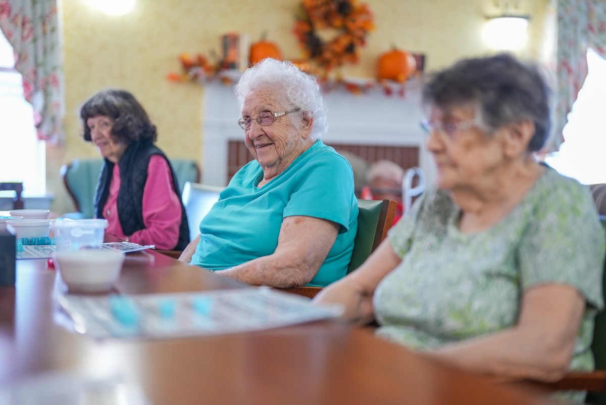 A group of elderly women socializing indoors.
