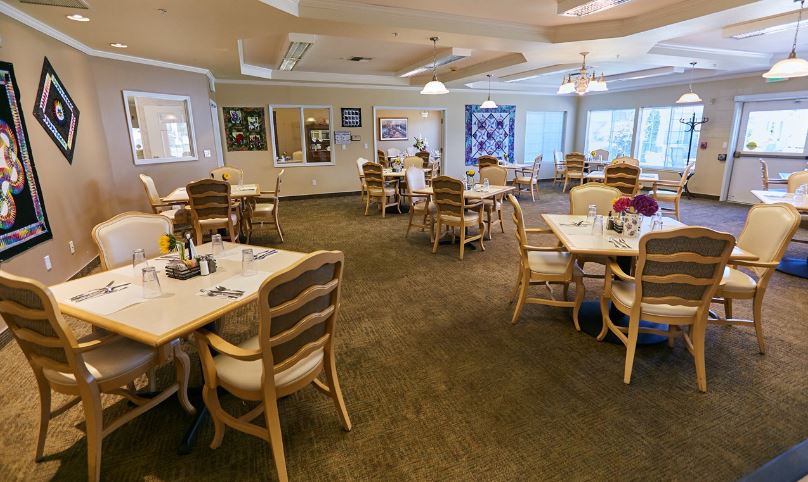 An empty dining room with neatly arranged tables and chairs, ready for guests.