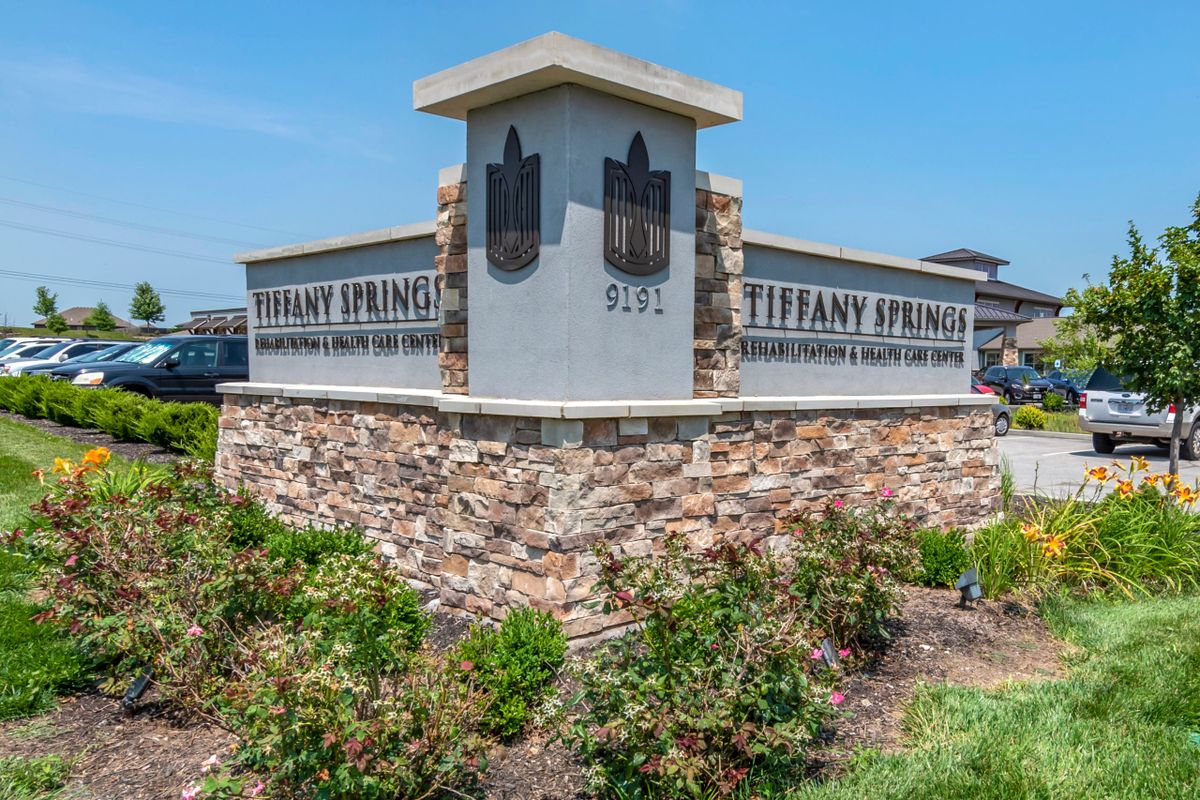 Stone entrance sign for Tiffany Springs with landscaping.
