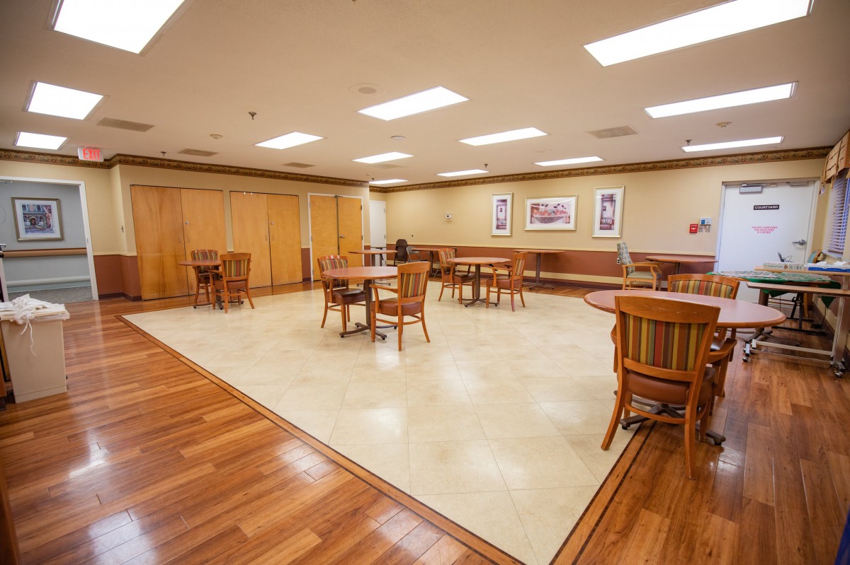 Spacious conference room with wooden flooring and multiple seating arrangements.