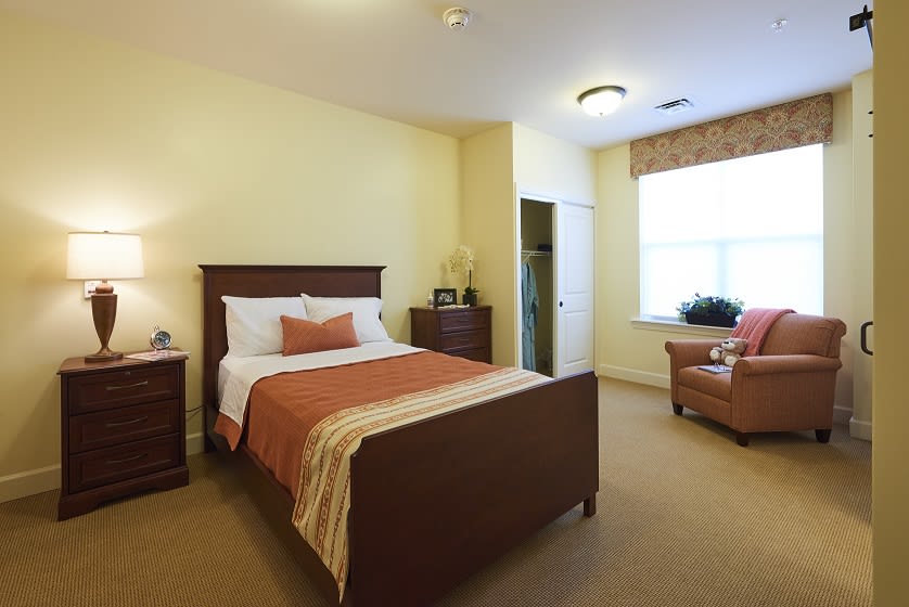 A cozy bedroom with a single bed, two nightstands, and a large window.