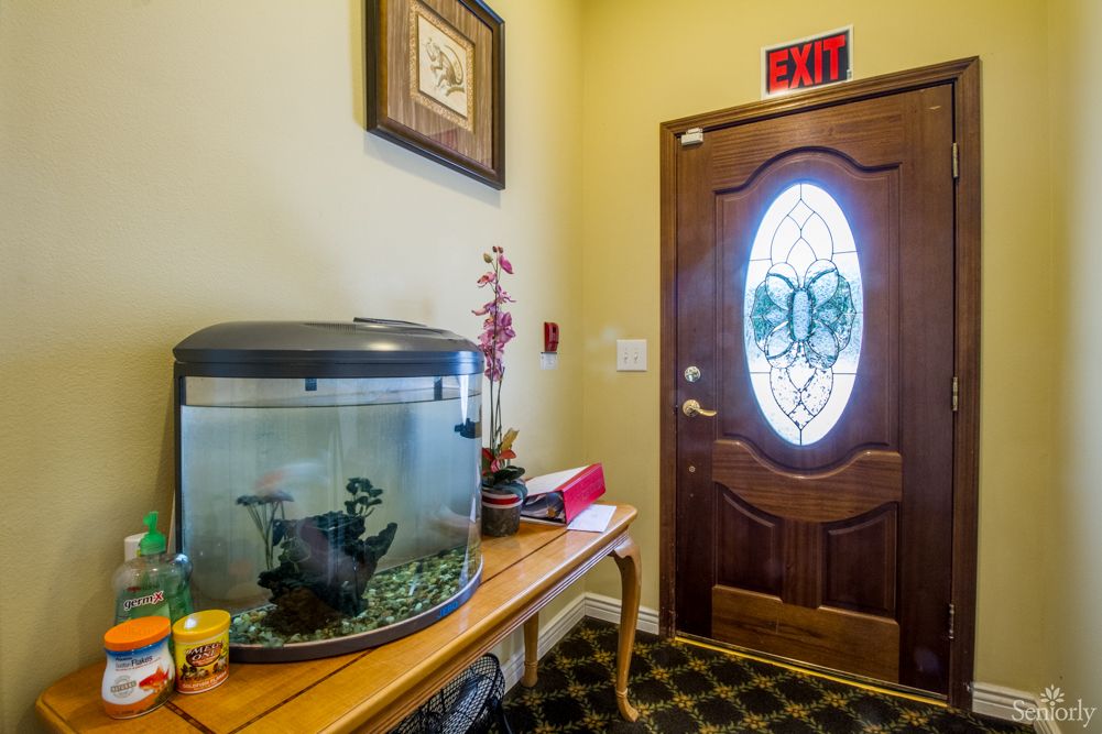 A cozy entryway with a fish tank on a wooden table next to an ornate front door.
