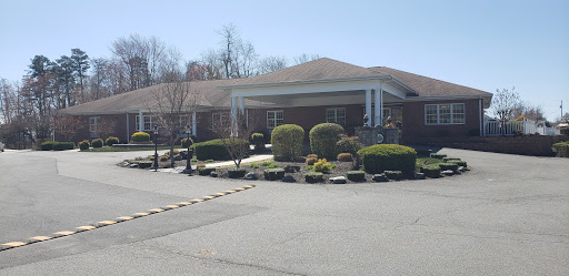 A well-maintained residential building with landscaped gardens under clear skies.