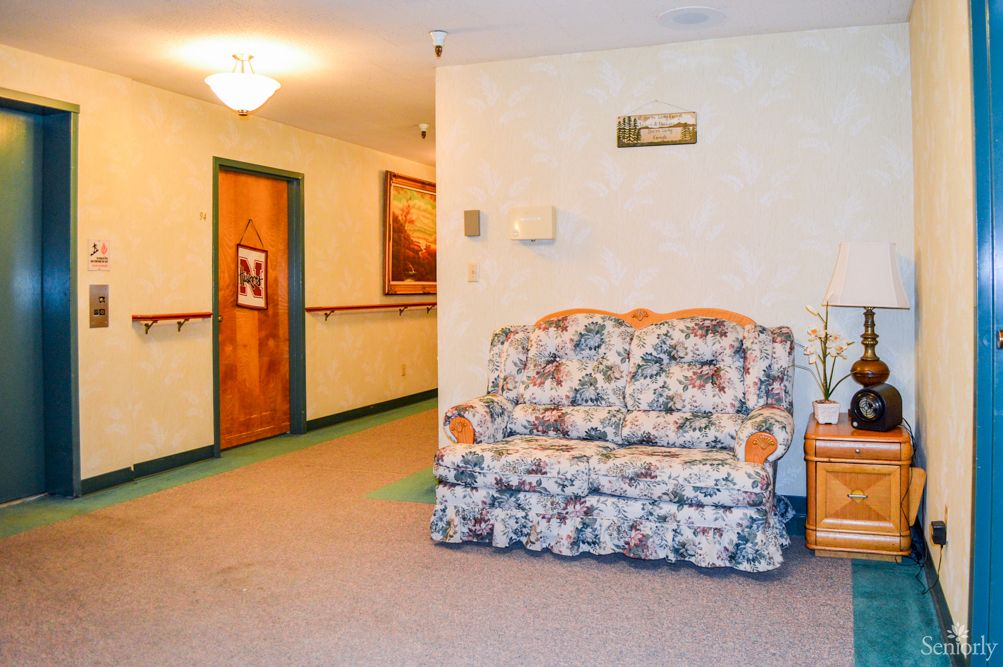 A cozy hallway with a floral-patterned couch and paintings on the wall.
