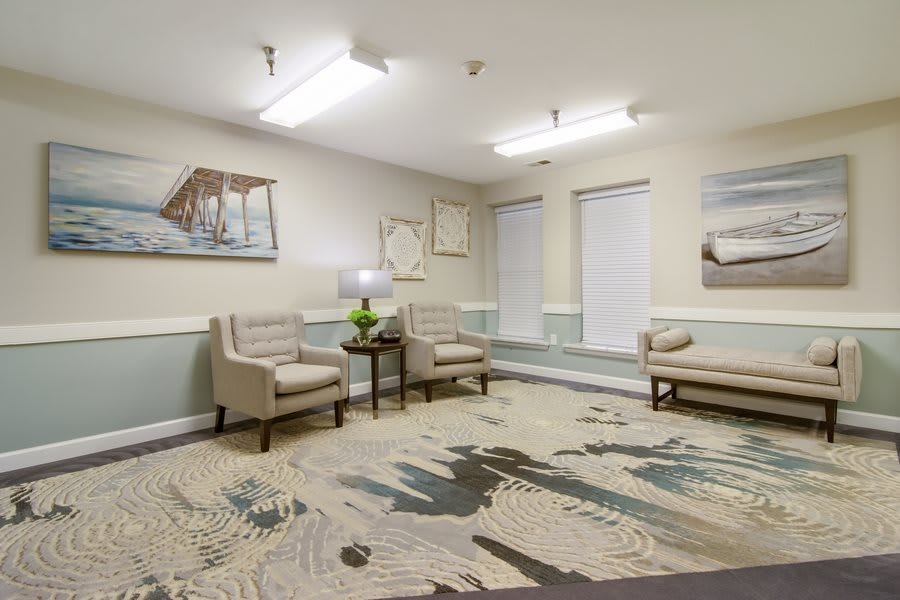 A modern waiting room with comfortable seating and decorative artwork.