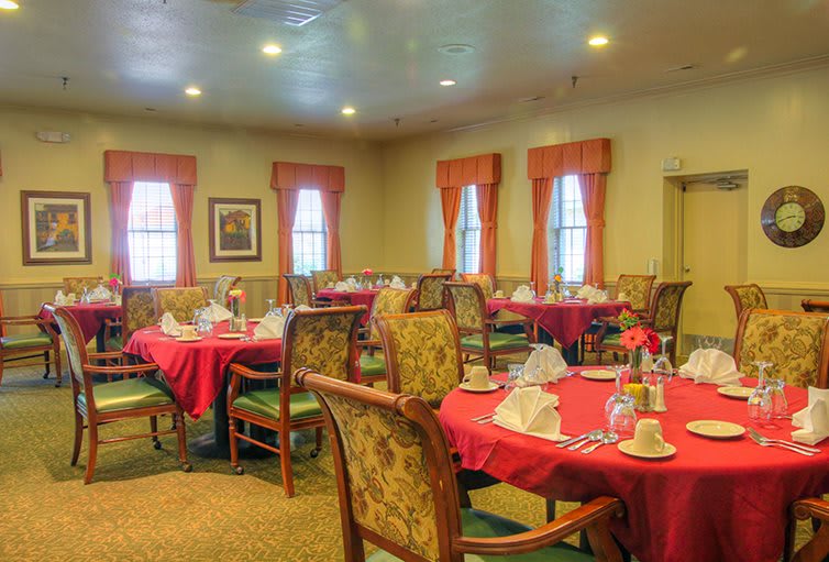 A cozy dining room with multiple tables set for a meal.
